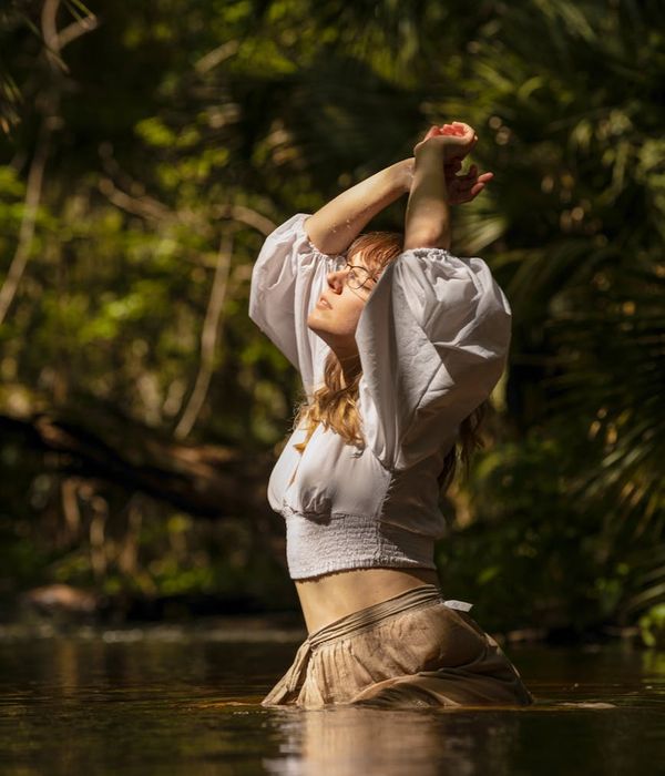 Woman meditating peacefully with a serene green light glow.